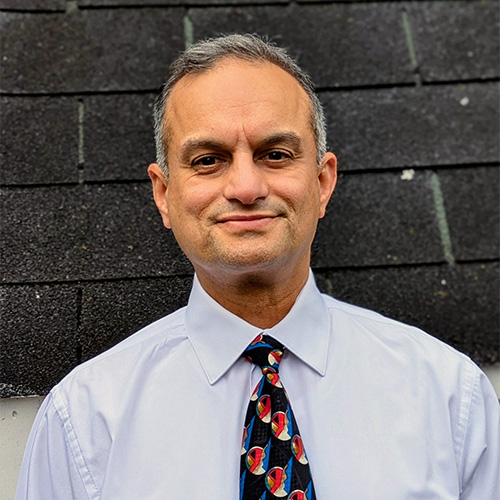Rahul Tikekar, in a light shirt and colored tie, works for George Mason