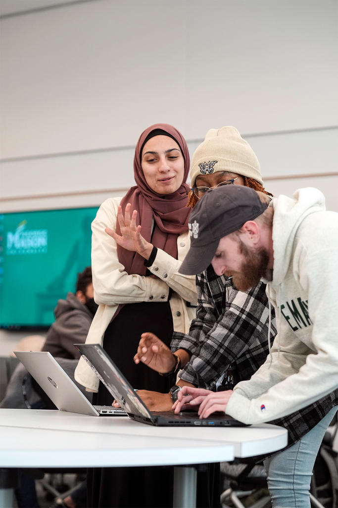A multiethnic trio of students work on operating an autonomous vehicle through a computer