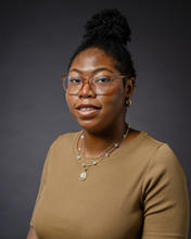 African-American woman wears curly braids in a bun