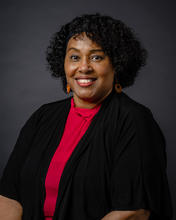 An African-American woman with a curly bob smiles