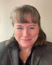 Linda Sheridan wears a gray suit