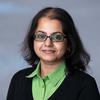 A headshot of CS associate professor Shvetha Soundararajan wearing a green collared shirt and black sweater.